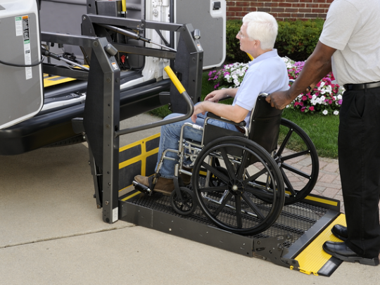 Man in wheelchair being lifted into van