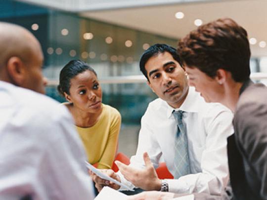 Co-workers talking around a table